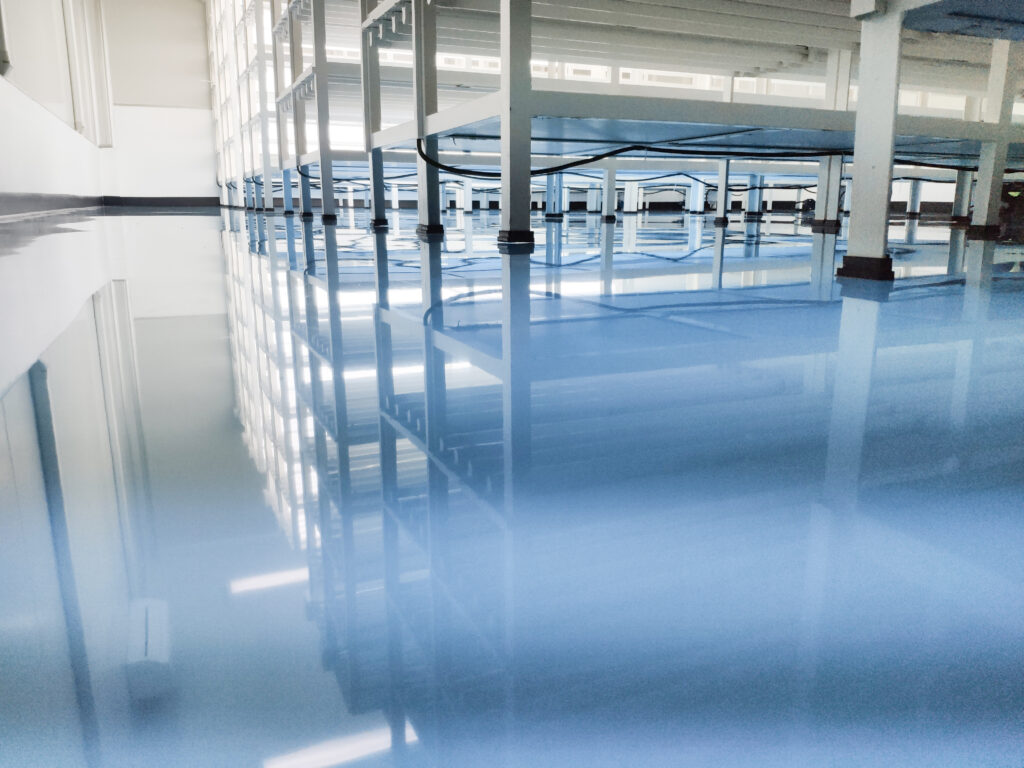 a cable under rack legs at sea blue epoxy floor. (Industrial epoxy floor)