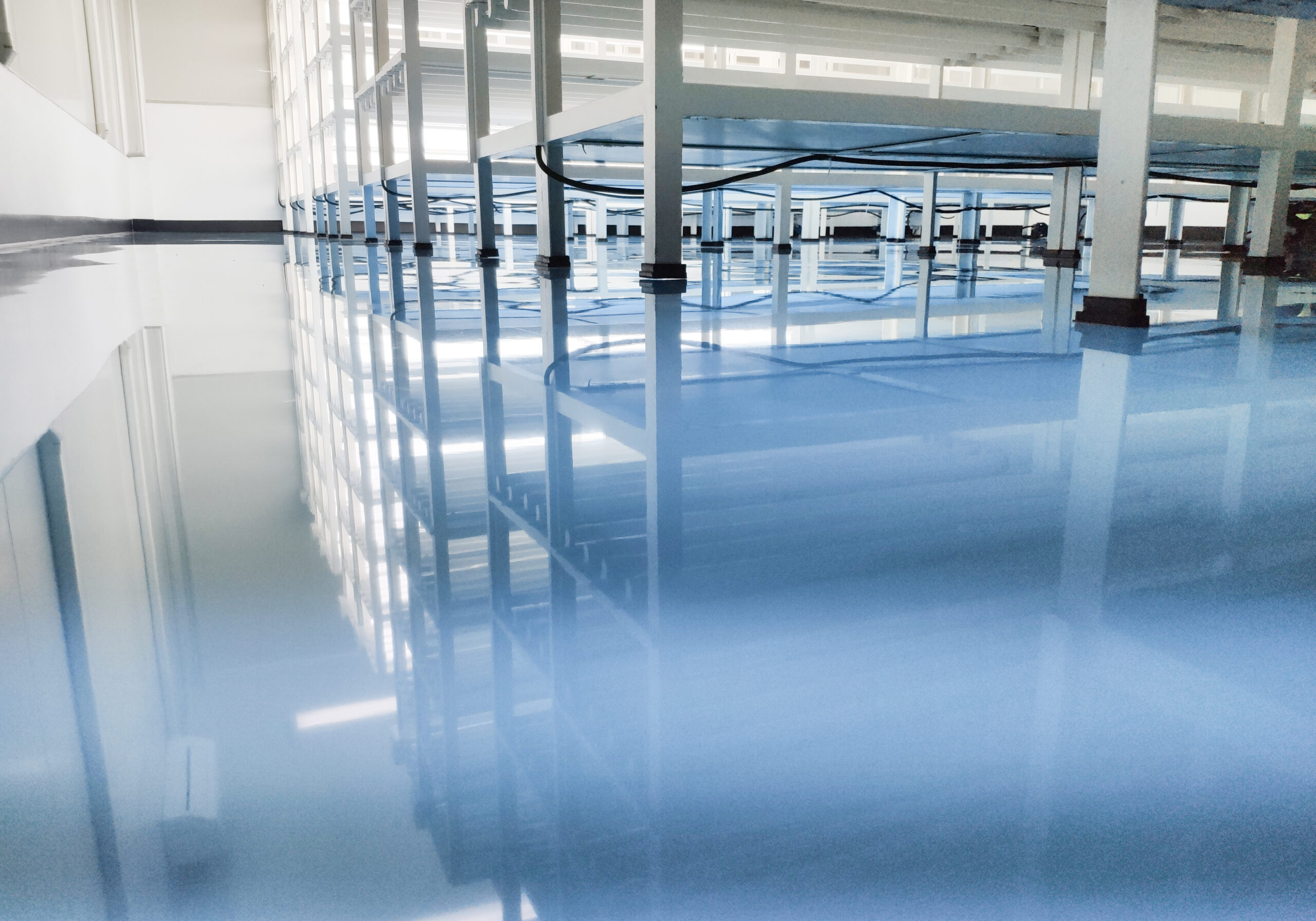 a cable under rack legs at sea blue epoxy floor. (Industrial epoxy floor)